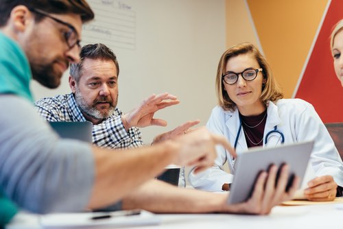 Medical professionals looking at an ipad
